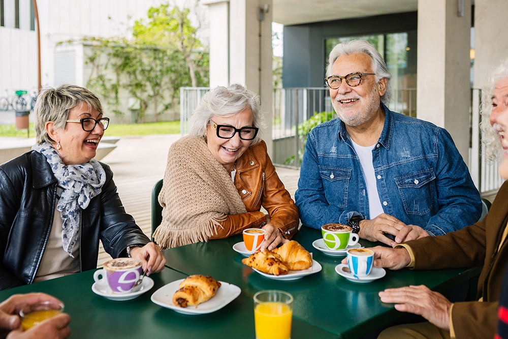 Happy group of seniors grabbing brunch together and talking