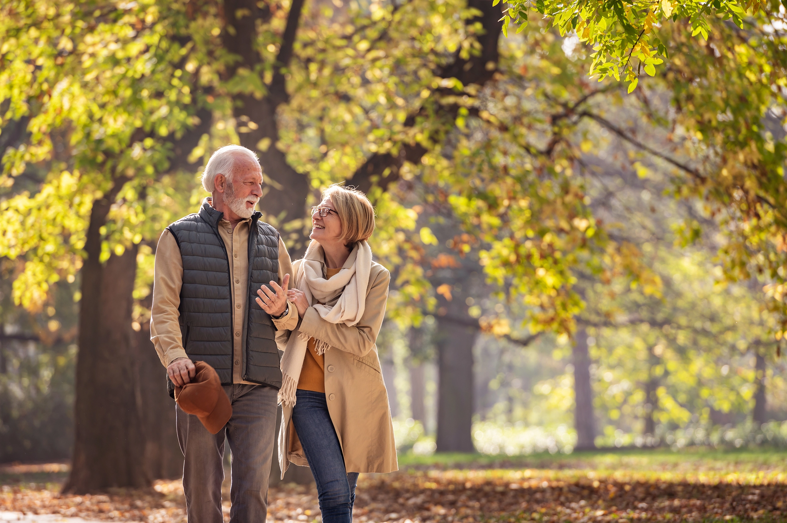 Two older people go for a walk in the forest